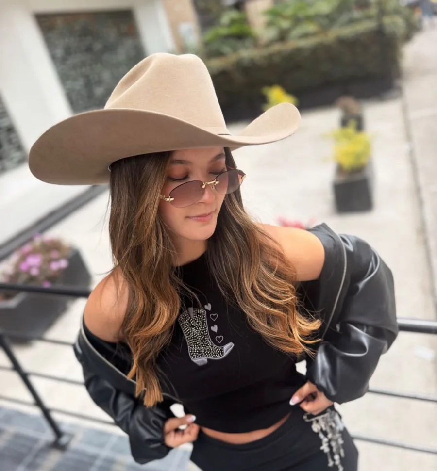 Clienta con sombrero y top negro bordado de María Oliva